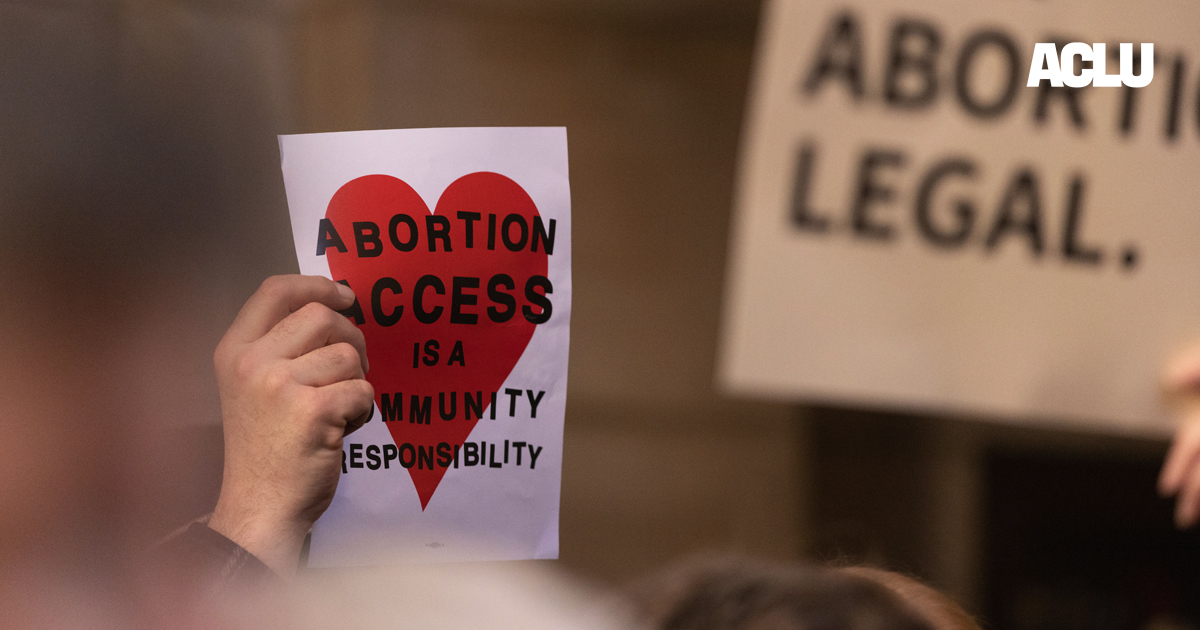 A Nebraskan holds a sign reading "Abortion access is a community responsibility"
