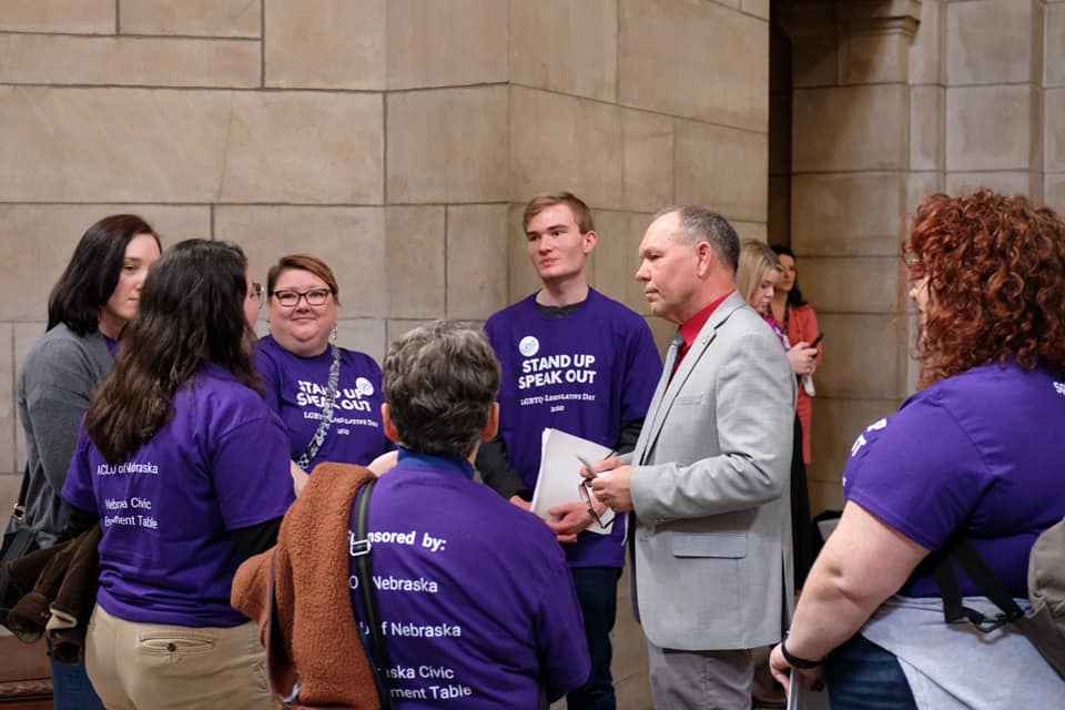 lobbyists in purple shirts talk to their state senator