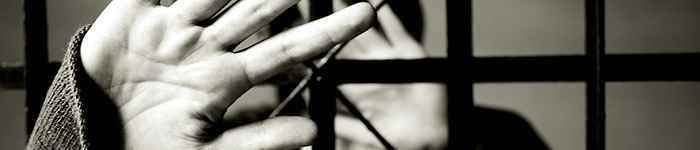 image of hands pushing out of a jail cell