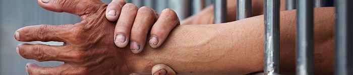 hands reaching out of a jail cell