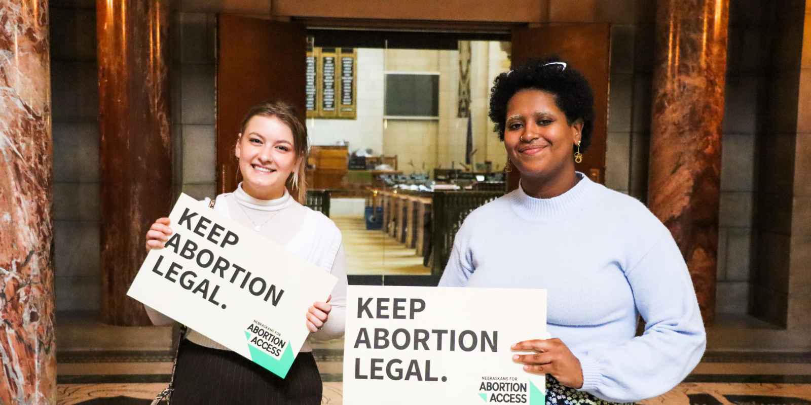 Advocates hold signs reading "Keep Abortion Legal."