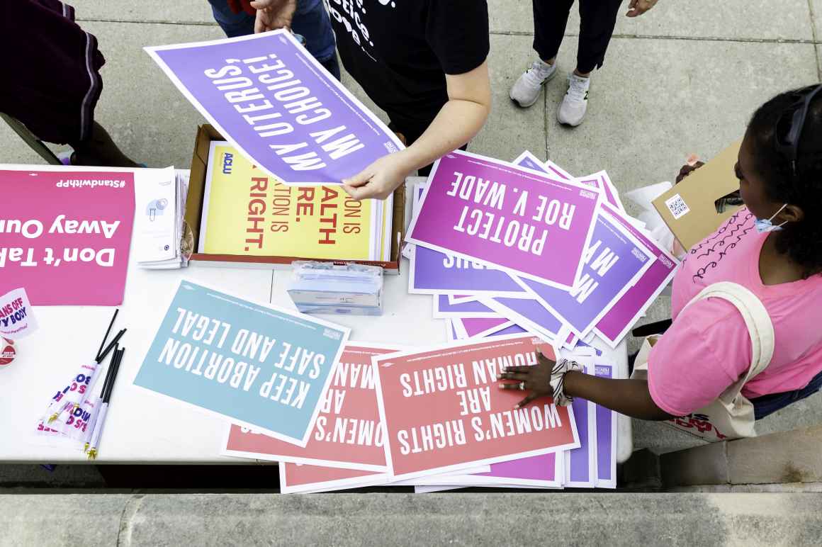 Reproductive justice rally attendees grab posters in Lincoln.