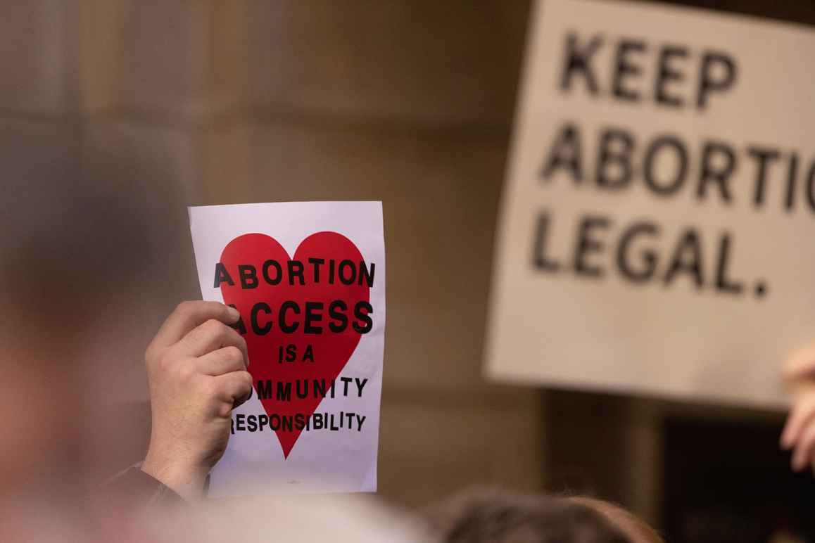 A Nebraskan holds a sign reading "Abortion access is a community responsibility"