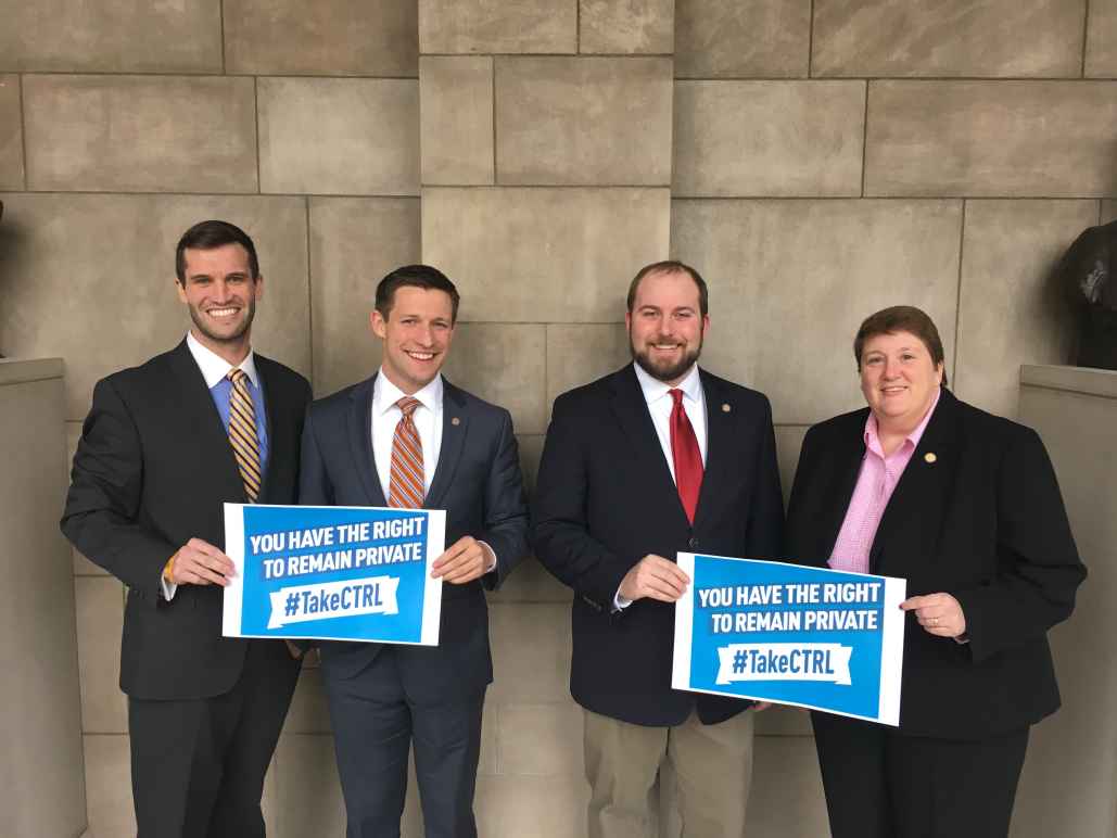 Sen. Tyson Larson, Sen. Adam Morefeld, Sen. Matt Hansen, and Sen. Laura Ebke with signs saying "you have the right to remain private. #TakeCTRL"