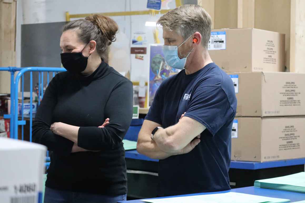 ACLU of Nebraska Executive Director Danielle Conrad and Eagle Printing & Sign employee Rick Hallet look at boxes of printed ballot applications. The ACLU is sending more than 300,000 early voting ballot applications to registered voters in Lincoln and Oma