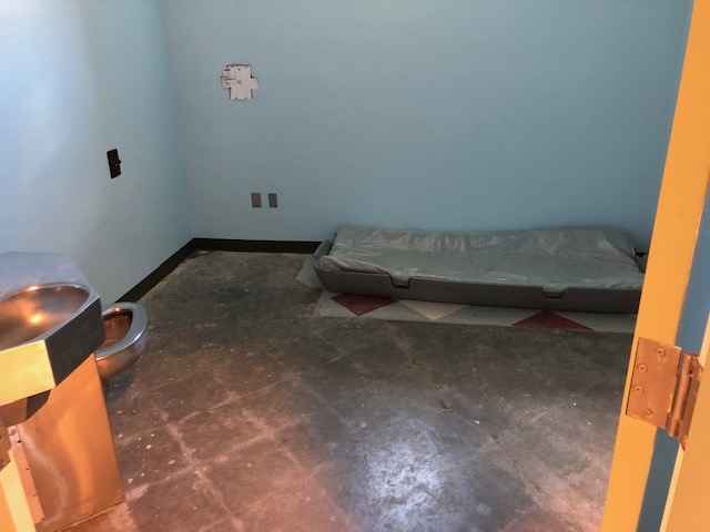 A photo taken at the YRTC in Geneva in the summer of 2019 shows a mattress on the floor of a barren room and a combined toilet and sink in the corner.