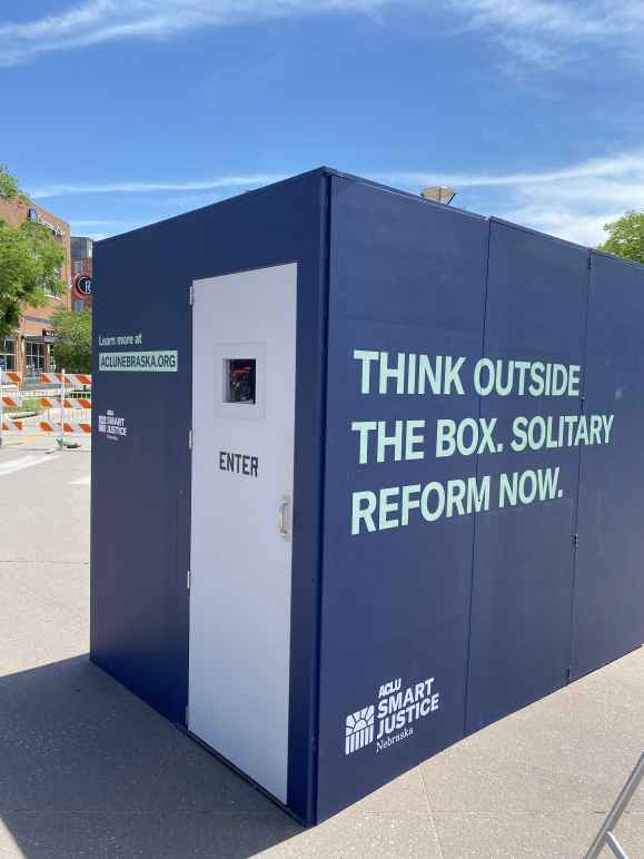 The ACLU of Nebraska's solitary replica cell reads "Think outside the box. Solitary reform now."