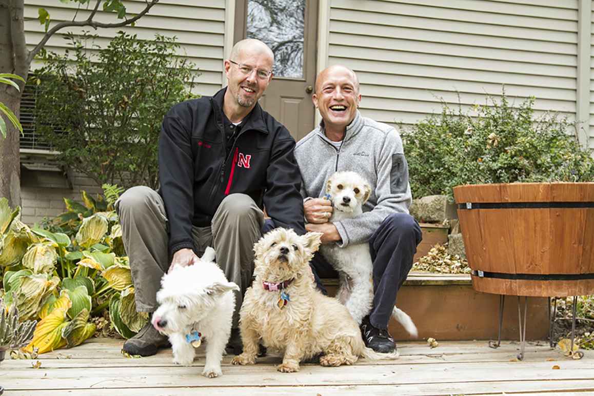 Todd and Joel outside of their home with their dogs.