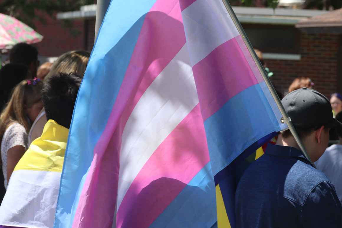 A Nebraskan holds a trans pride flag at Hastings Pride.