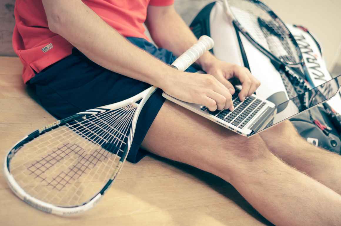 student with laptop and tennis racket