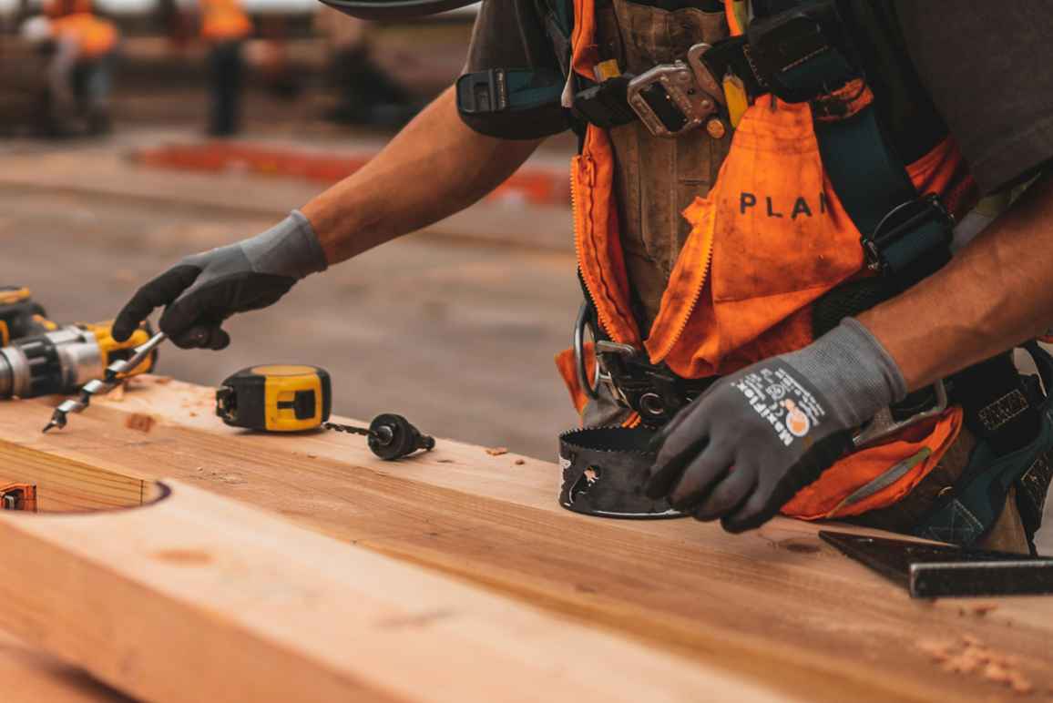 A construction worker reaches for a drill bit. Image courtesy Jeriden Villegas.