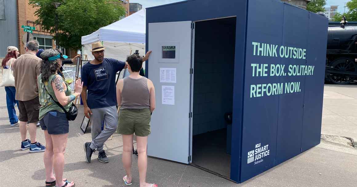 The ACLU of Nebraska's solitary replica cell reads "Think outside the box. Solitary reform now."