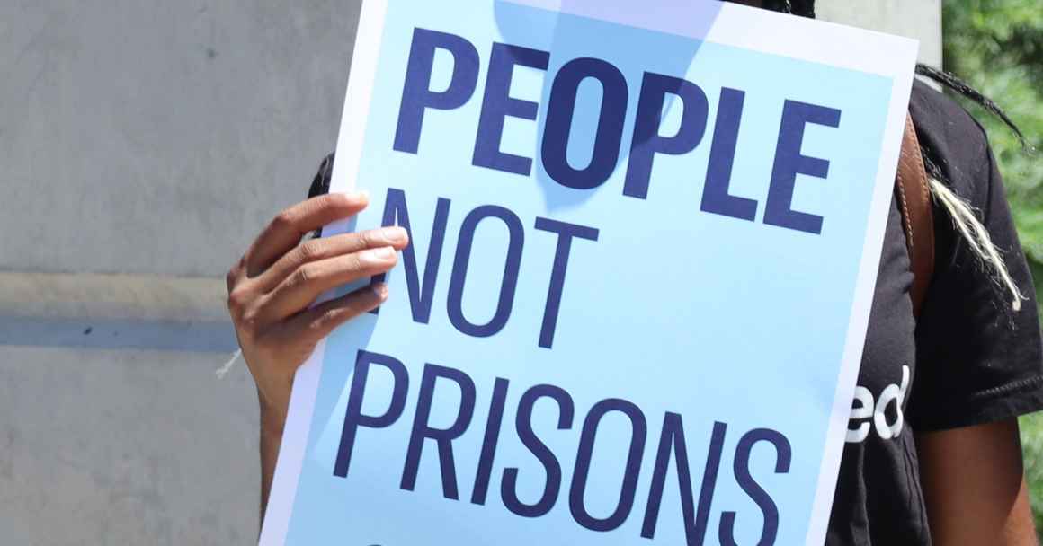 A poster reads "people not prisons"