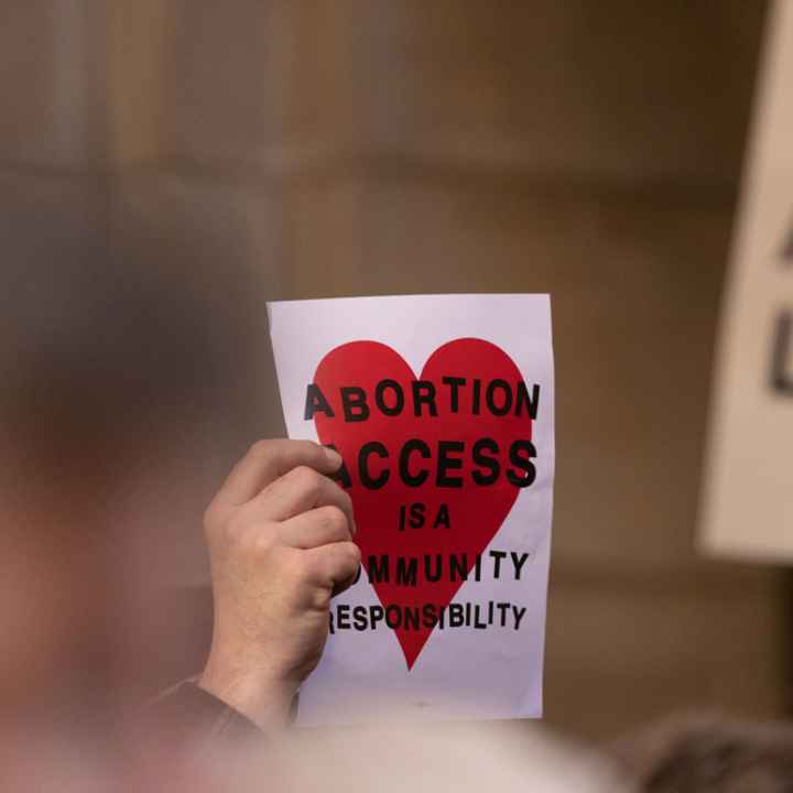 A Nebraskan holds a sign reading "Abortion access is a community responsibility"