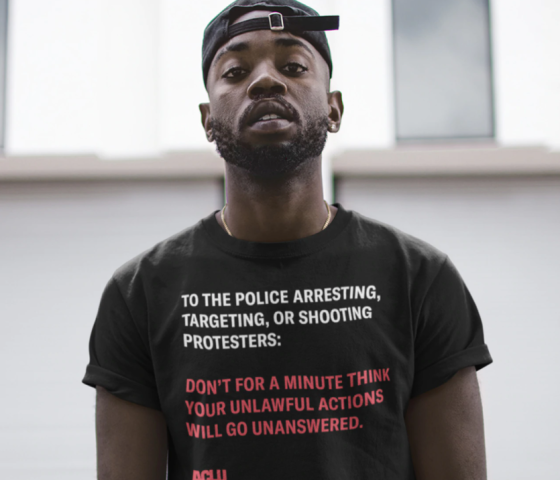 A shirt reading "to the police arresting, targeting or shooting protesters, don't for a second think your unlawful actions will go unanswered."